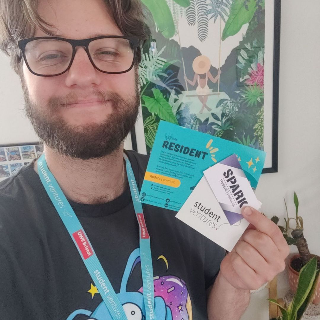 Luke takes a selfie showing off a lanyard and flyers from the UWE Student Ventures team.