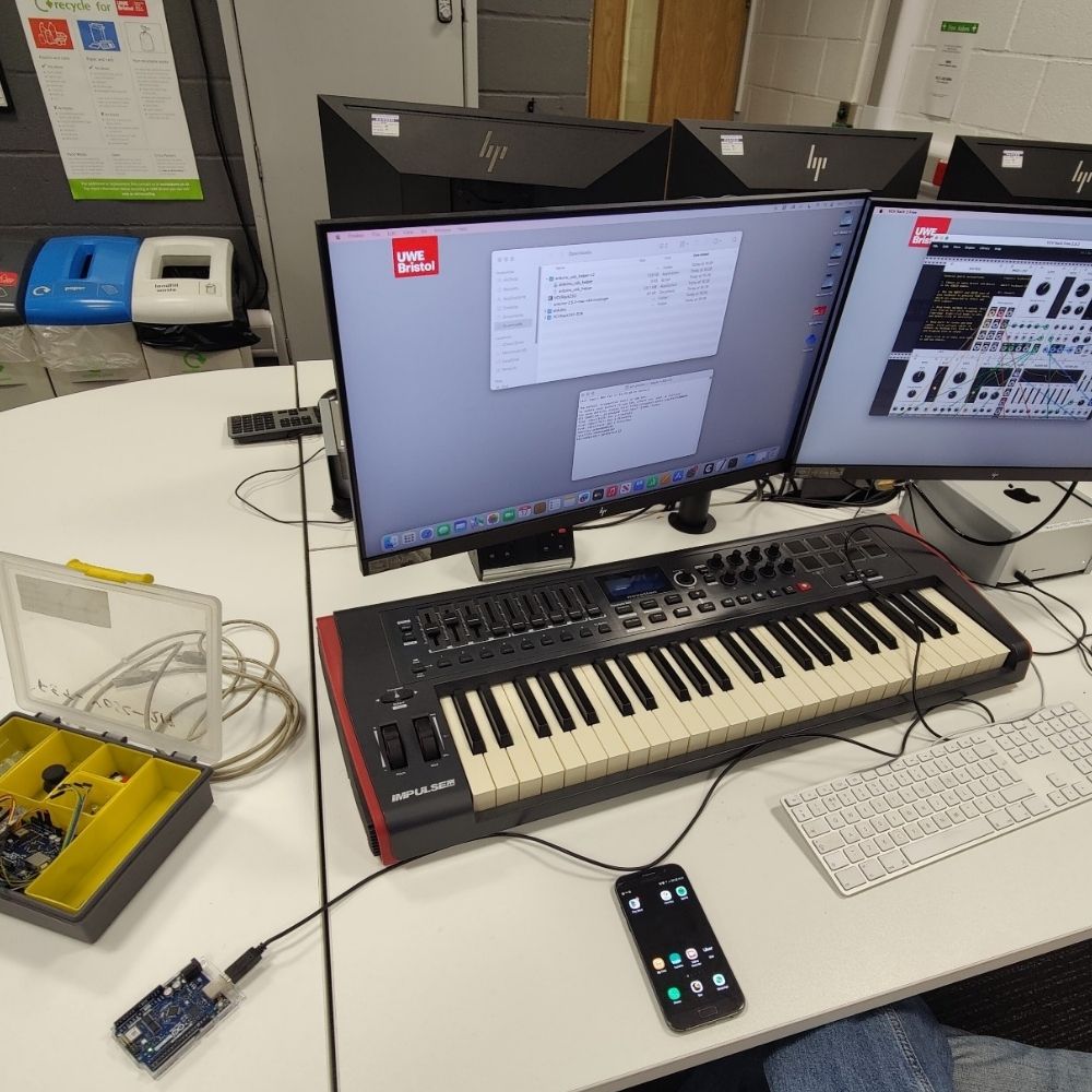 An Arduino, a MIDI Keyboard and various cables plugged into an iMac computer running VCV Rack. 